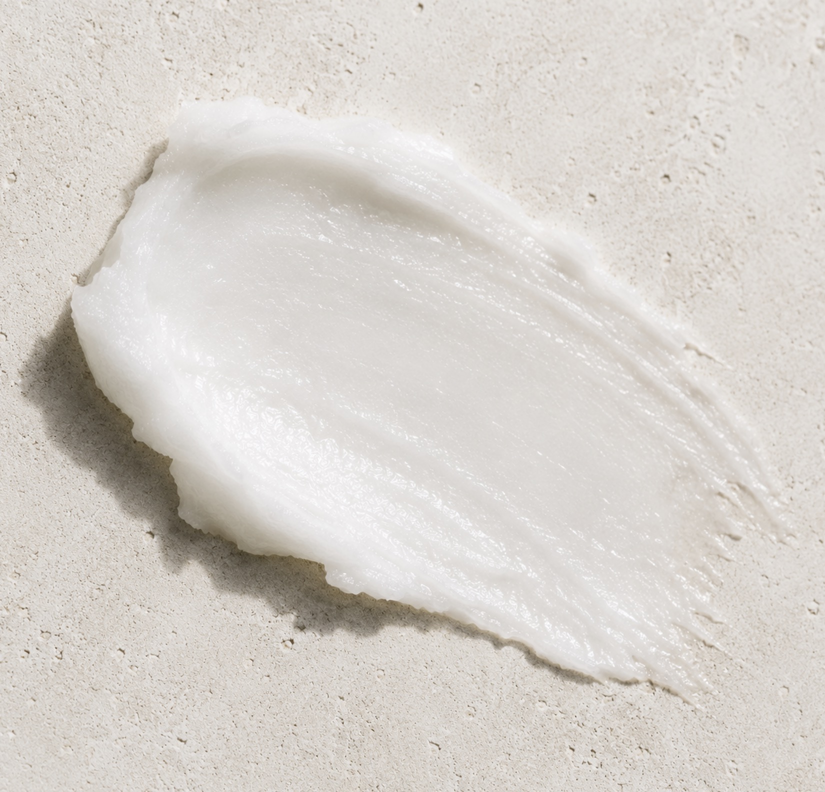 Swipe of white coconut oil on a pale stone surface