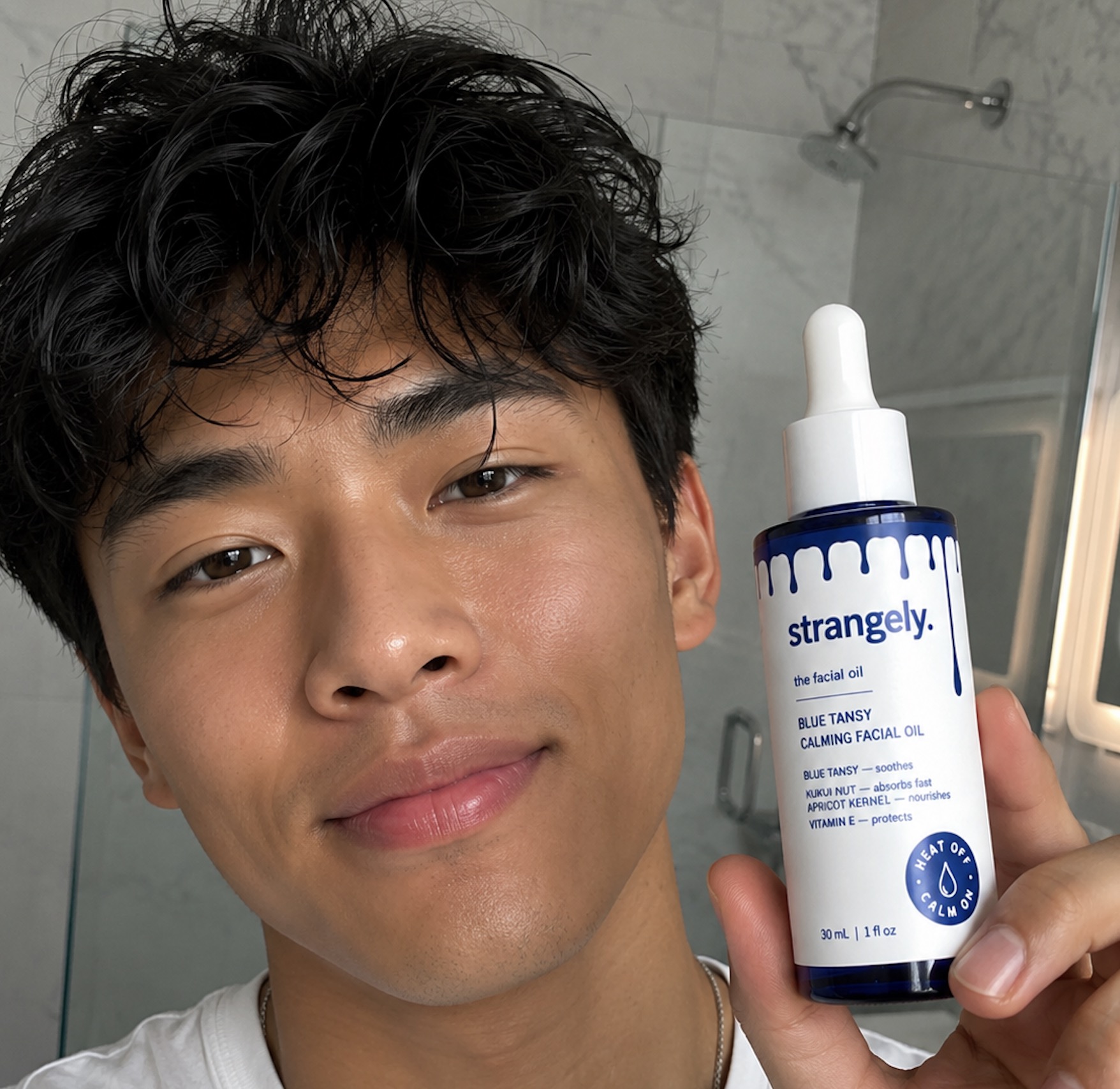 Model holding the strangely. Blue Tansy Calming Facial Oil bottle