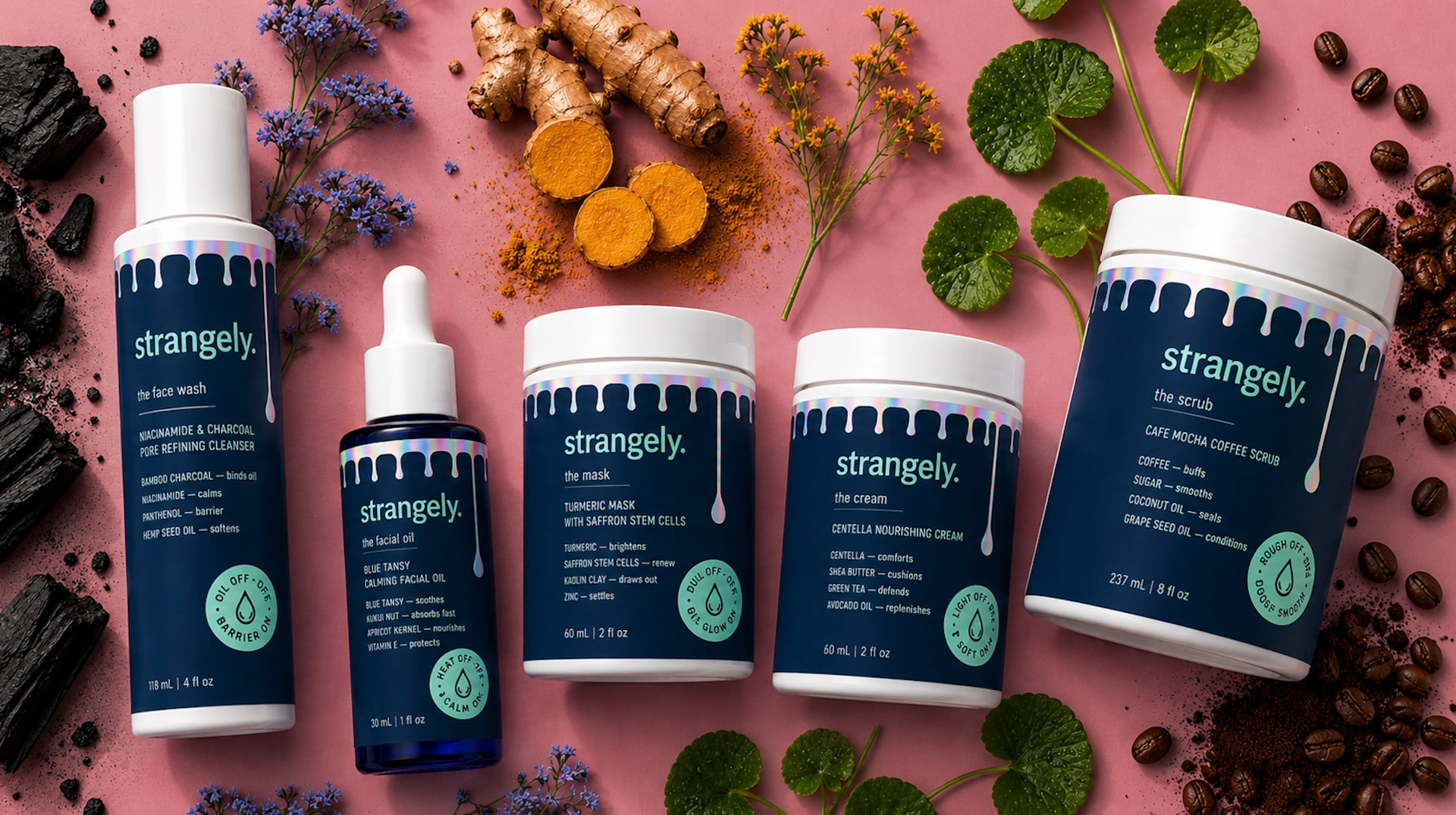 strangely. five-product lineup on a pink background with charcoal, turmeric, blue tansy, centella, and coffee beans