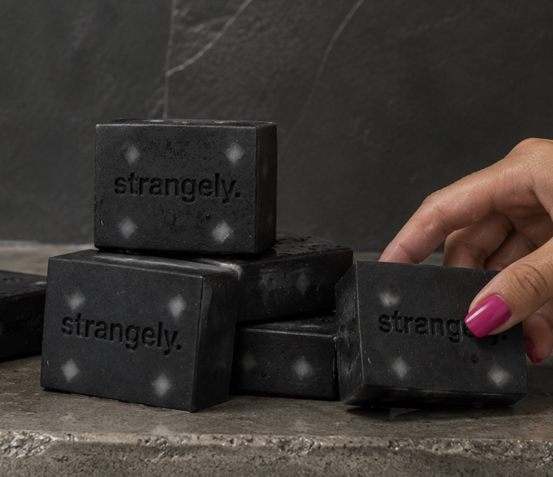 Strangely. product lineup on a dark stone surface